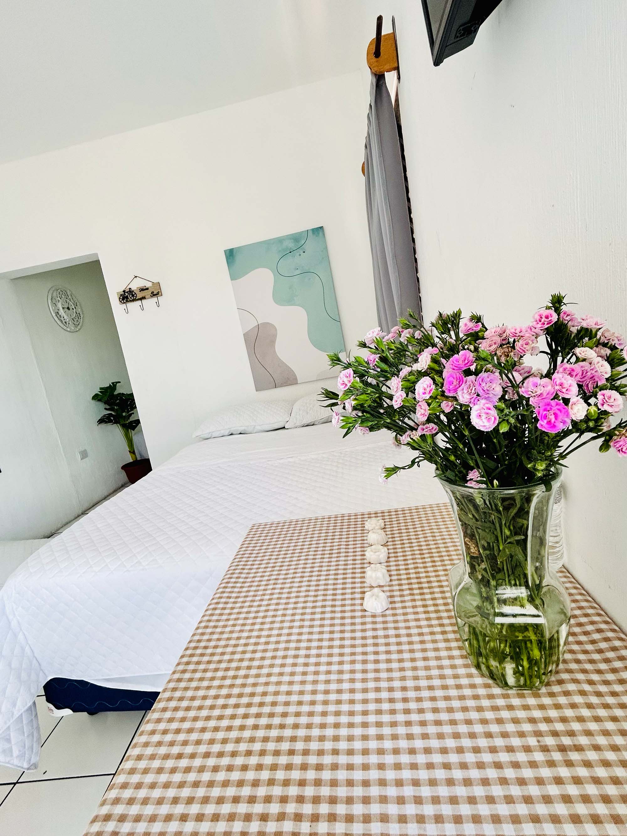 Habitación con flores rosadas y TV